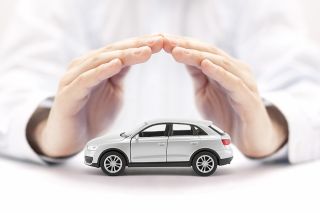 Foto: Hände über kleinem Auto